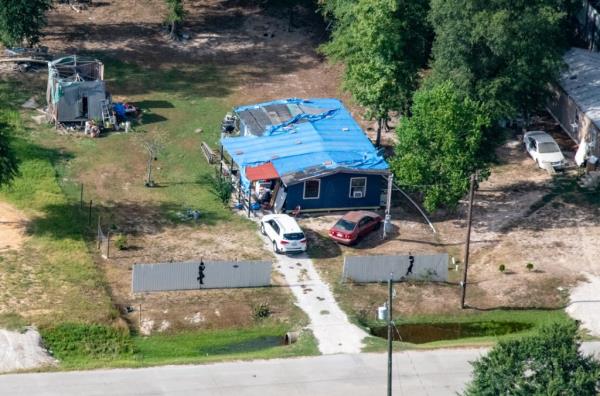 An aerial view of a home in co<em></em>lony Ridge with a blue tarp for a roof