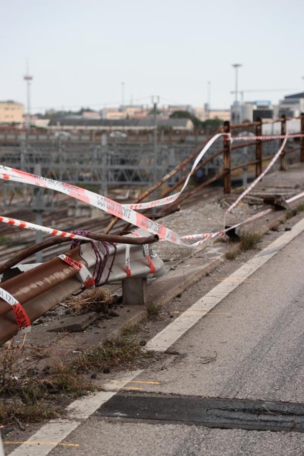bent and broken guardrail with police tape across on overpass wher<em></em>e the bus crashed through. 