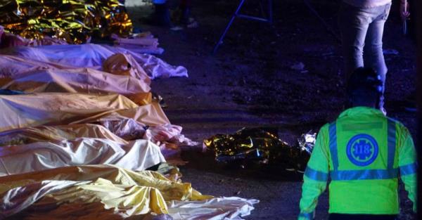 Bodies lay covered in sheets on the ground wher<em></em>e a deadly bus crash occurred. 