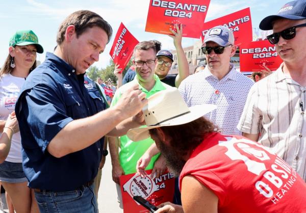 Ron DeSantis signs a supporter's hat, as he campaigns at the Iowa State Fair in Des Moines, Iowa, U.S. August 12, 2023